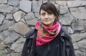 Bild på Sofie Wahlström som står vid en stenvägg