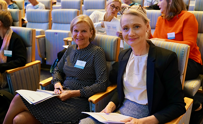 Beatrice Hopstadius och Karin Tegmark Wisell sitter i aulan.
